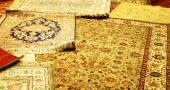 Turkish carpets are unrolled and piled for the customer to examine.