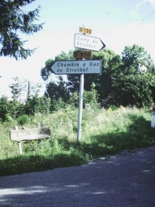 The signs to Struthof:and the gas chamber. The wooden sign on the lower left points to a bar and restaurant. 