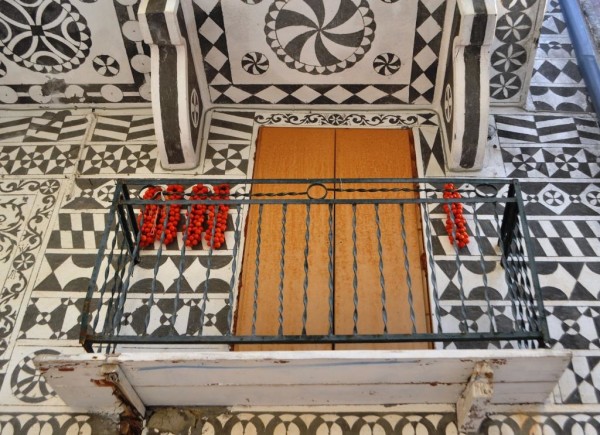 Traditional Chios architecture decorated with geometric motifs -- and brightened by tomatoes hung for drying.