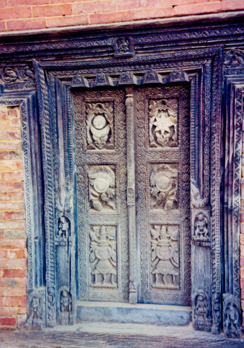 An ornately carved wooden doorway in Bhaktapur